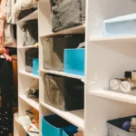 Closet Organization: How to make everything fit. Perfectly organized walk-in closet with color coded clothes and neatly folded items on white shelves